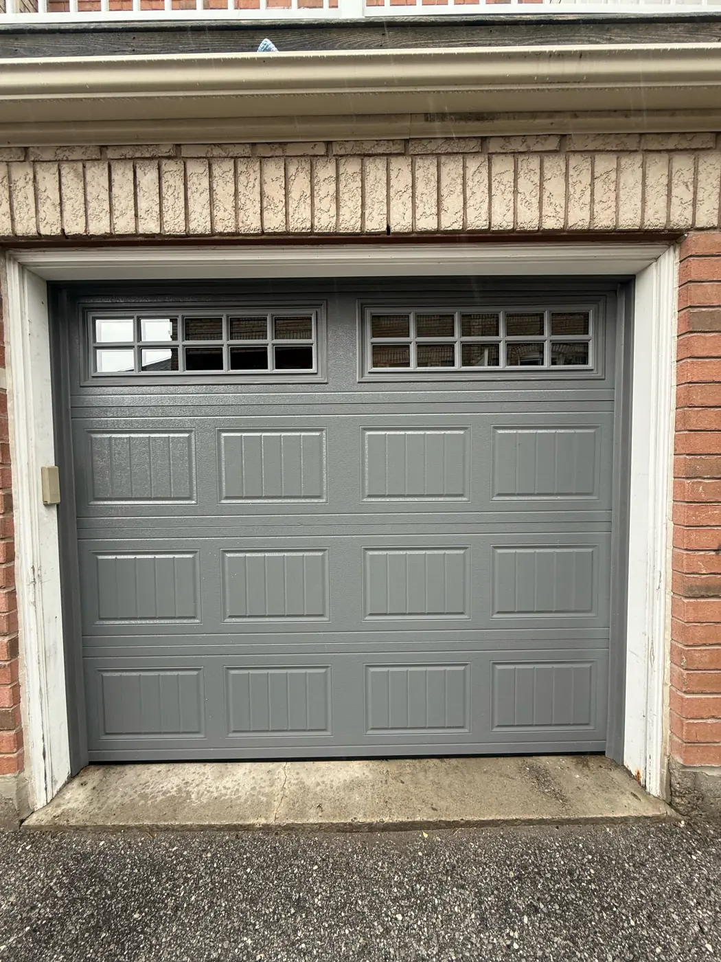 Grey carriage-style garage door with windows, suited to many Toronto homes